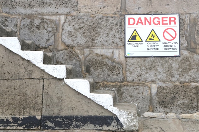 Stairs against the wall with 3 warning signboards